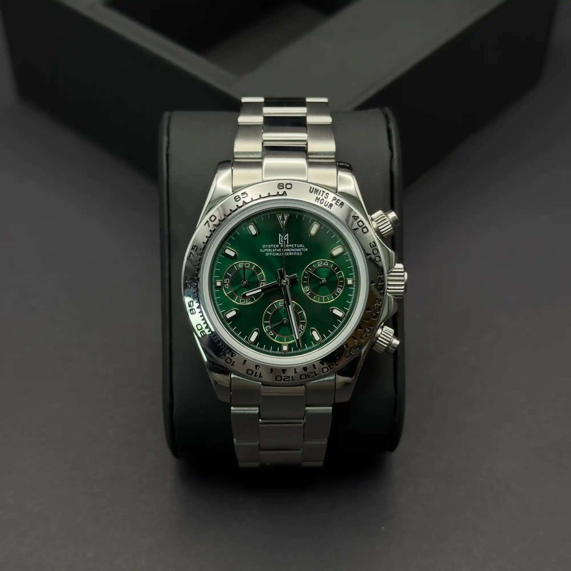 Une montre-bracelet en acier inoxydable avec un cadran vert et trois sous-compteurs, équipée d'une lunette tachymétrique.